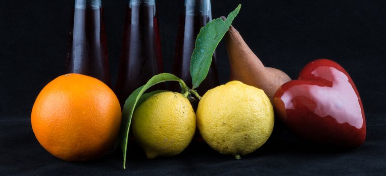 Orange, Lemon and Pear on black background.