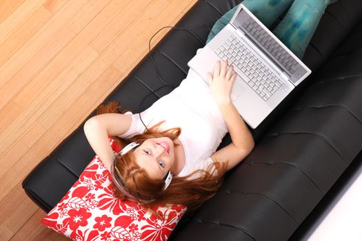 A young woman surfing on the Internet with a Laptop.  