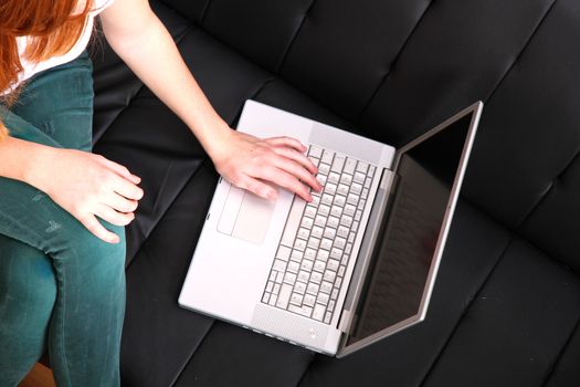 A young, brazilian woman surfing on the Internet with a Laptop.  