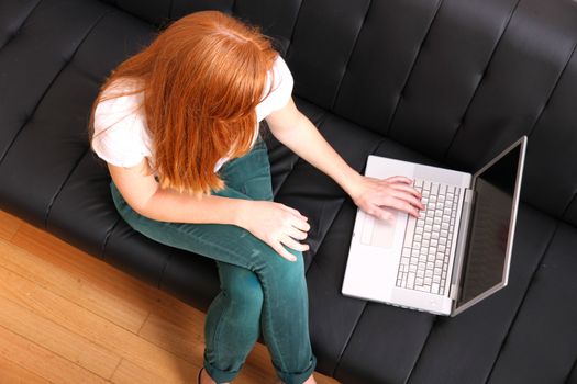 A young, brazilian woman surfing on the Internet with a Laptop.  