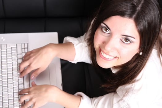 A young woman surfing on the Internet with a Laptop.  
