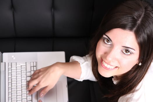 A young woman surfing on the Internet with a Laptop.