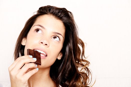 Portrait of a beautiful, latin Woman eating chocolate.