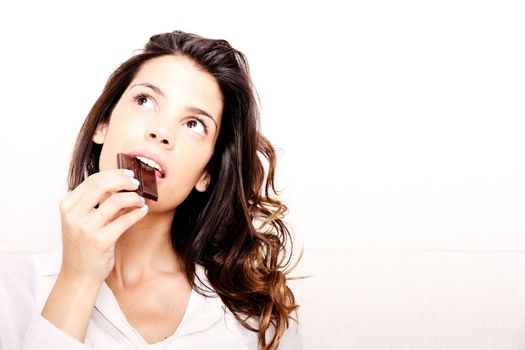 Portrait of a beautiful, latin Woman eating chocolate.