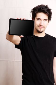 A young hispanic man holding a Tablet PC.