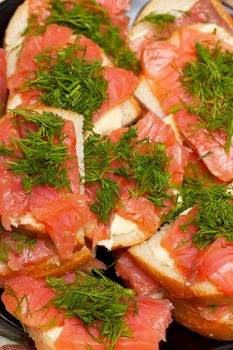 A heap of sandwiches with red fish meat and green parsley