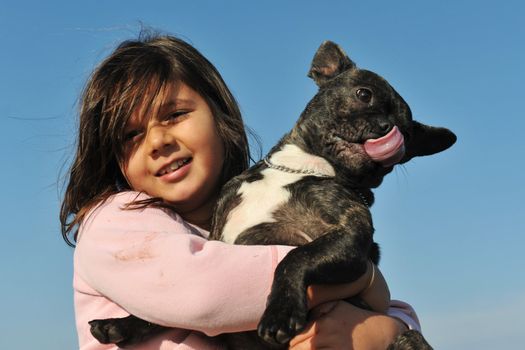 portrait of a purebred french bulldog and little girl on a blue sky