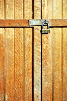 wooden door locked with a golden padlock