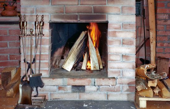 Fireplace with flame and fire irons