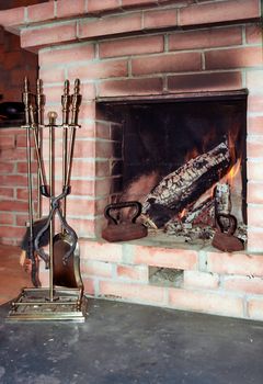 Fireplace with two old irons in it and fire irons