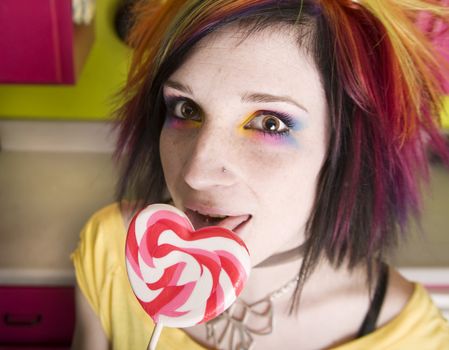 Alternative Girl in a Colorful Kitchen with a Heart Lollipop