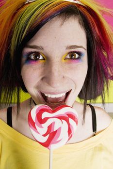 Alternative Girl in a Colorful Kitchen with a Heart Lollipop