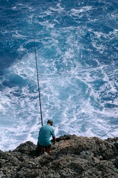 Man fishing in stormy sea