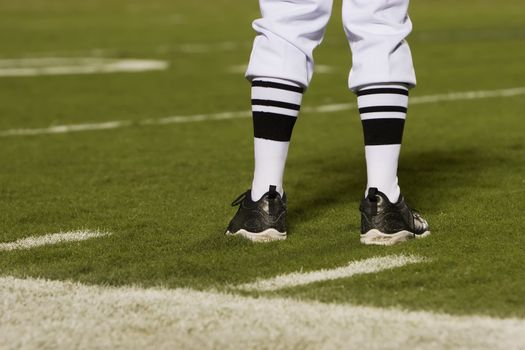 Referre's feet on a football field from behind.