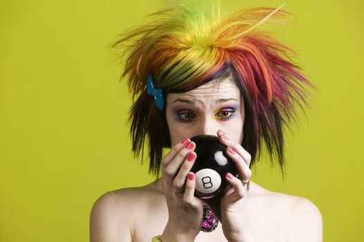 Close-up of a woman with bright mascara and colorful hair predicts the future