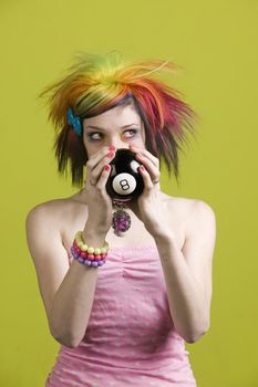 Close-up of a woman with bright mascara and colorful hair predicts the future and looks up to the right