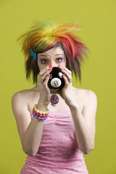 Close-up of a woman with bright mascara and colorful hair predicts the future