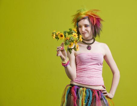 Pretty young woman with colorful punk clothes considers plastic flowers.