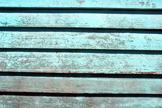 wall of an old wooden boards with blue paint faded