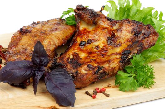 Delicious Barbecue Pork Ribs with Greens and Basil closeup on Cutting Board