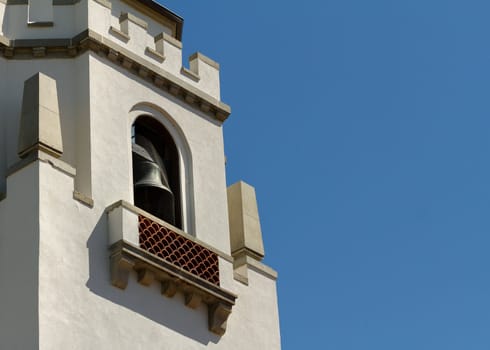Older bell tower style building against a blue sky