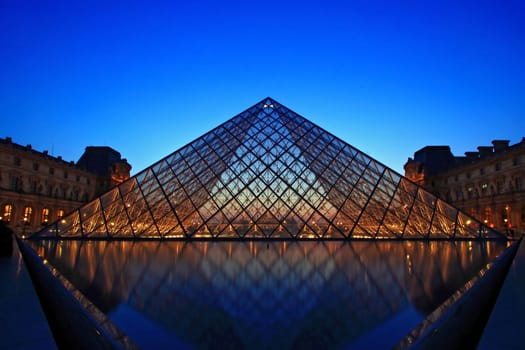 PARIS - APRIL 16: Shining of Louvre pyramid at Evening during the Egyptian Antiquities Summer Exhibition April 16, 2010 in Paris. This is one of the most popular tourist destinations in France.