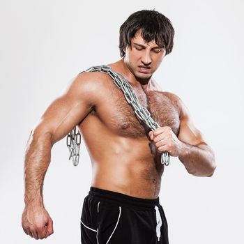 Agressive bodybuilder with chain over white background