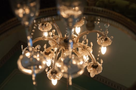 Classical Style Old Beautiful Crystal Chandelier glowing in darkness