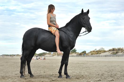 beautiful black horse on the beach and beautiful woman