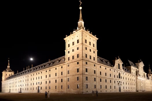 San Lorenzo de El Escorial Monastery  at night beautifully illuminated. Four towers are set off by black background.