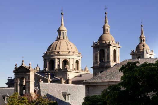 San Lorenzo de El Escorial Monastery - towers of the church and monastery are set of by a bright blue sky.