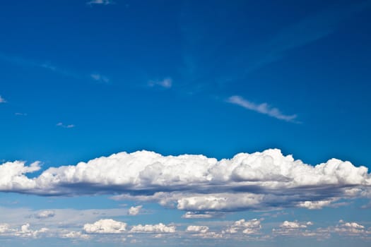 Blue summer sky with low white clouds with copy space