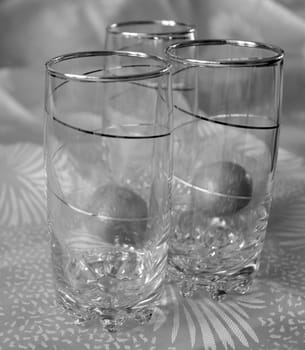 Three glasses, decorated with spiral pattern, and two tangerines