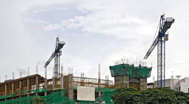 Sport Arena Building Under Construction with two Cranes