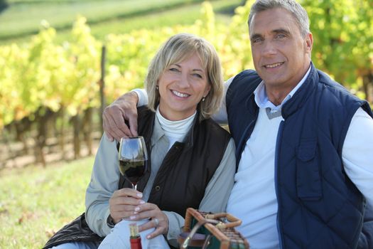 Couple tasting wine in a vineyard