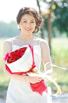 beautiful bride outdoors with rose bouquet