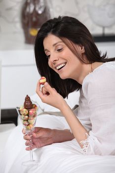 Cheerful woman eating Easter eggs
