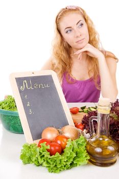 Menu board and vegetables with woman out of focus over white