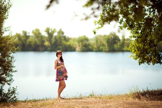 beautiful pregnant girl near the lake