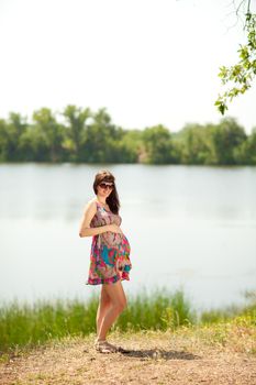 beautiful pregnant girl near the lake