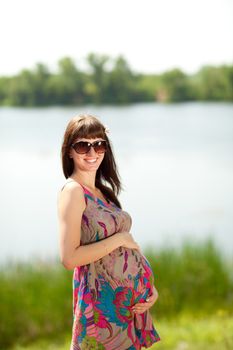 beautiful pregnant girl near the lake