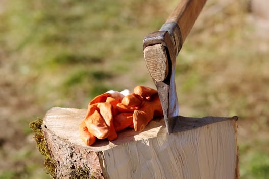 axe on wooden log with working protection gloves