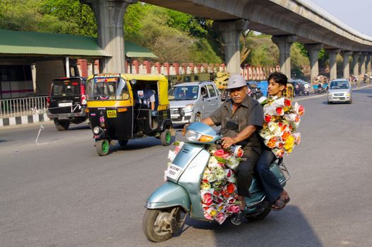 Man delivering flowers on a motorbike. M.G. road, Bangalore, India.