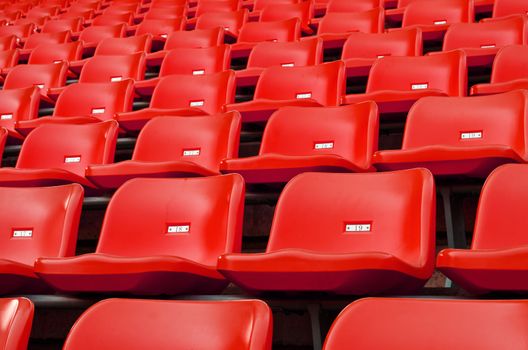 Red Empty plastic seats at stadium open door sports arena