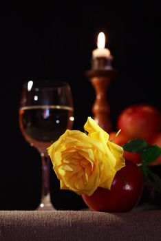 Vintage still life with beautiful yellow rose near white wine and fruits