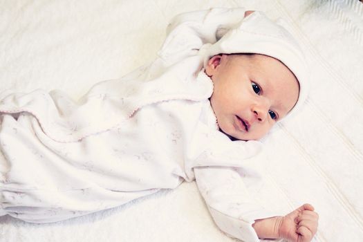 two weeks old baby girl on a white towel