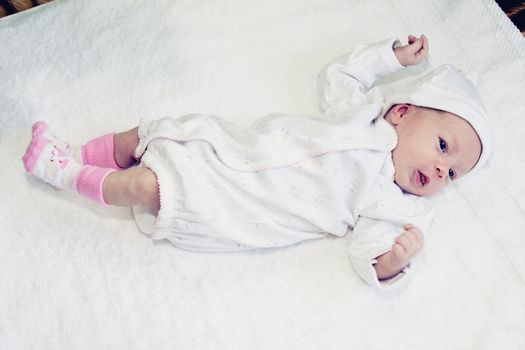 two weeks old baby girl on a white towel