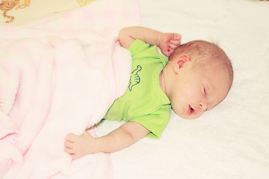 two weeks old baby sleeping in the bed