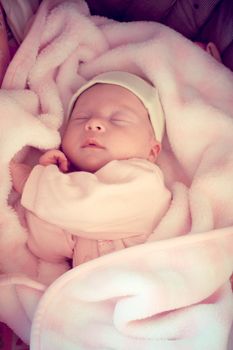 two weeks old baby sleeping in pink blanket