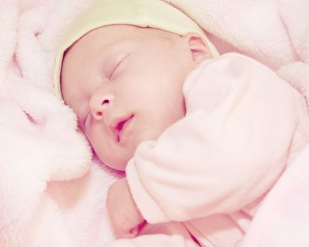 two weeks old baby sleeping in pink blanket